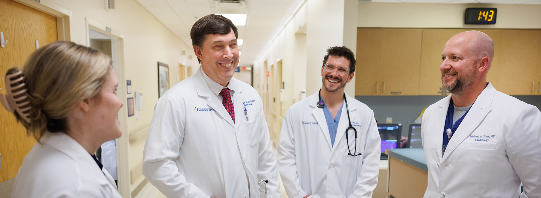 Dr. Michael Hall, second from left, standing in front of the nurses' station with three other cardiologists.